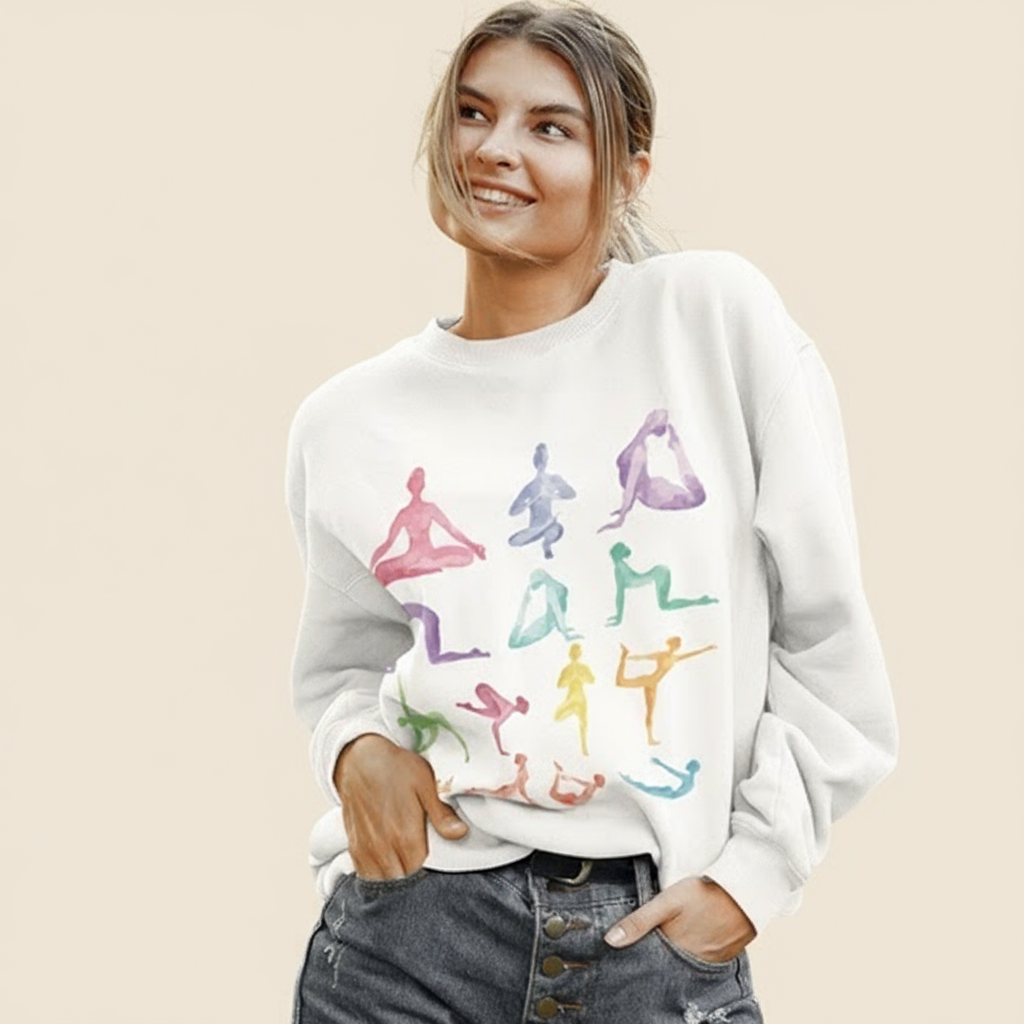 Woman wearing a white sweatshirt with colorful yoga pose illustrations.