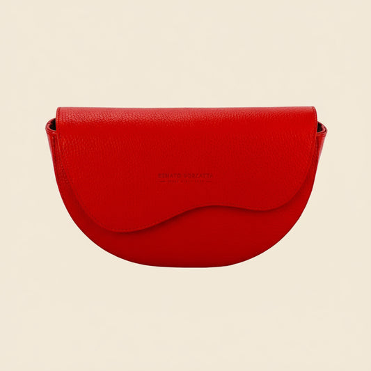 Red handbag with a visible brand name on a tan background