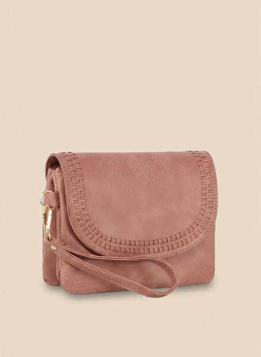 Pink suede handbag with a strap on a white background