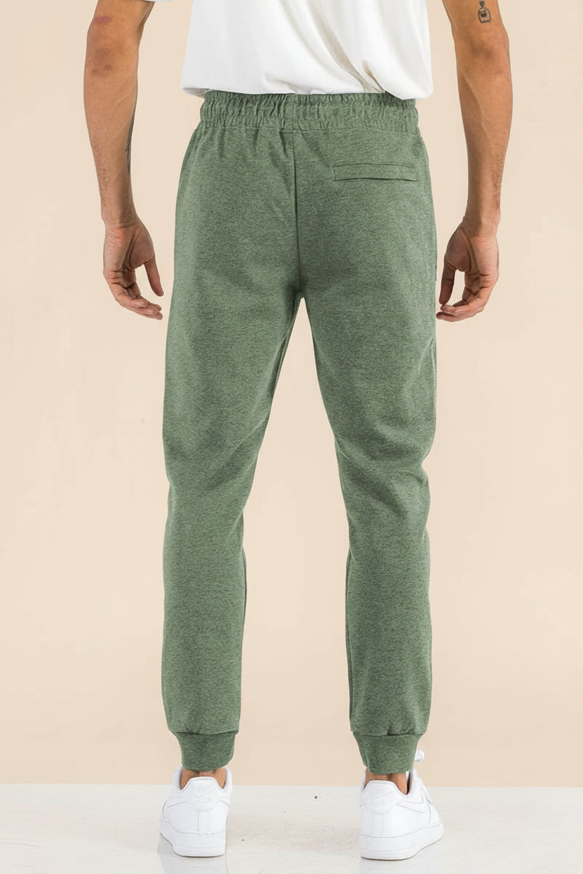 Person wearing green sweatpants on a white background