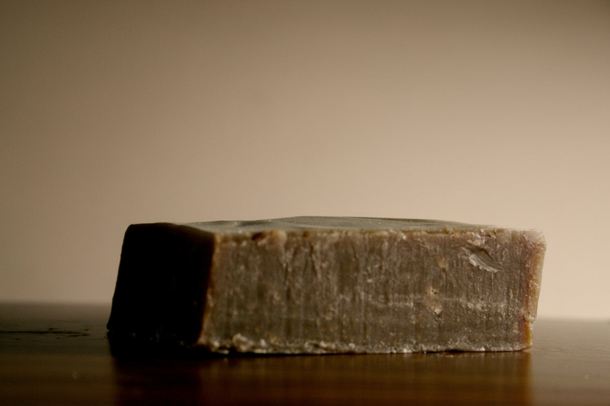 Bar of soap on a wooden surface with a plain background
