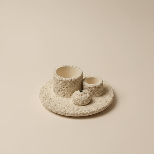 Ceramic items in front of tan background.