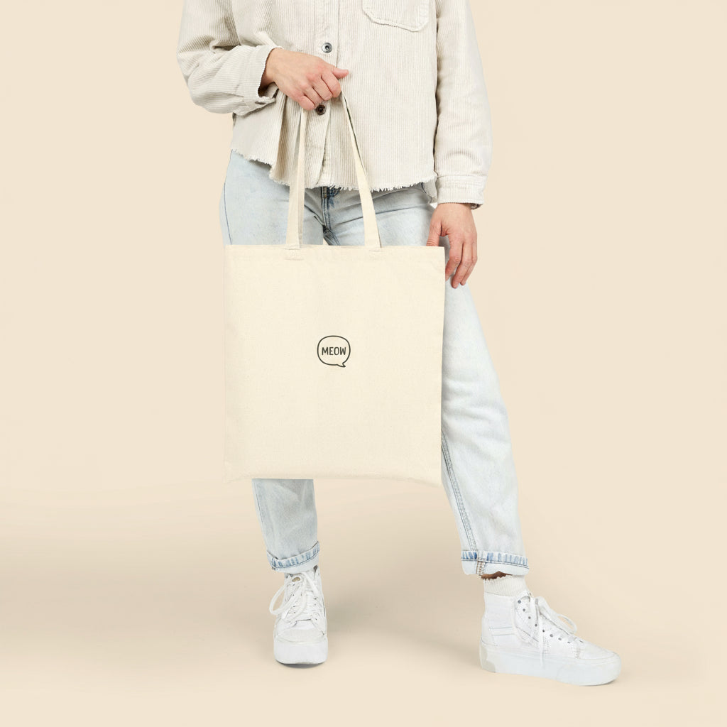 Model carrying Meow Tote Bag in canvas color