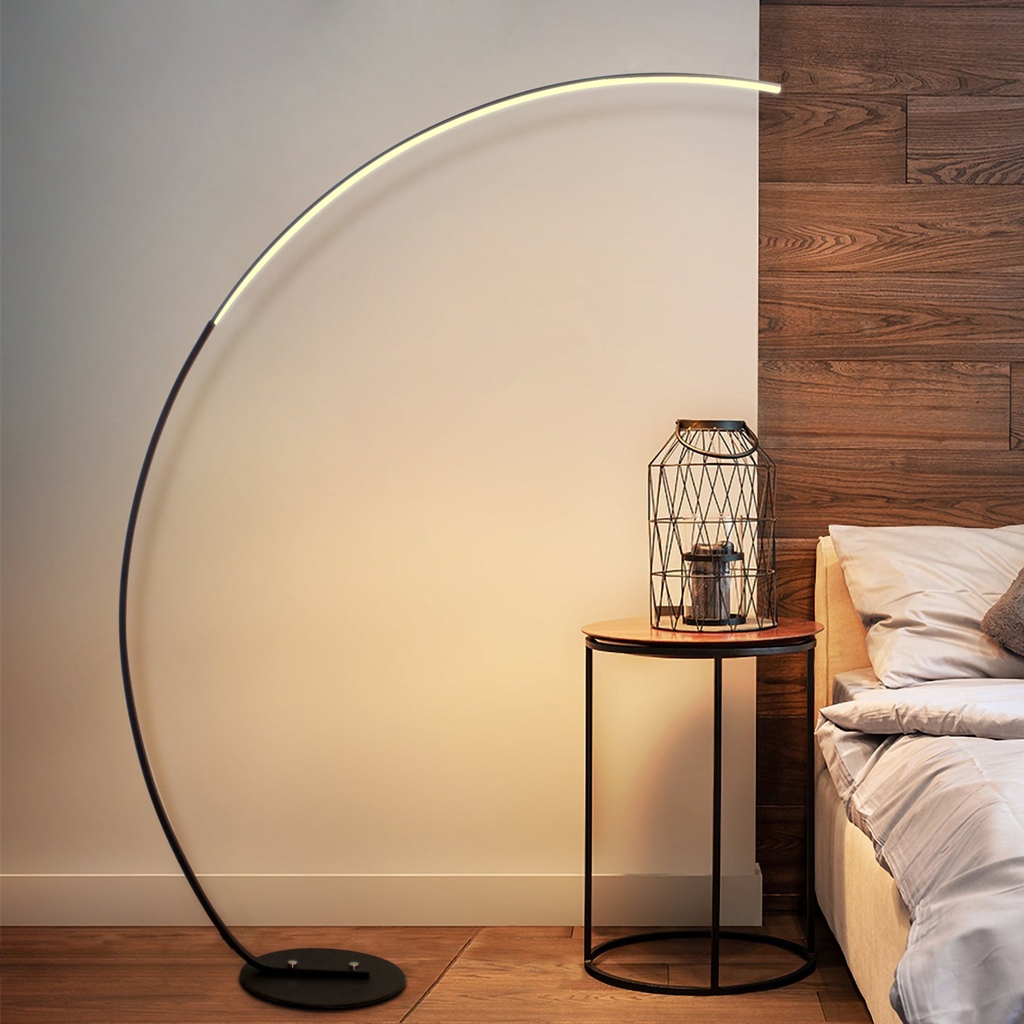 Modern floor lamp with a curved design in a bedroom setting.