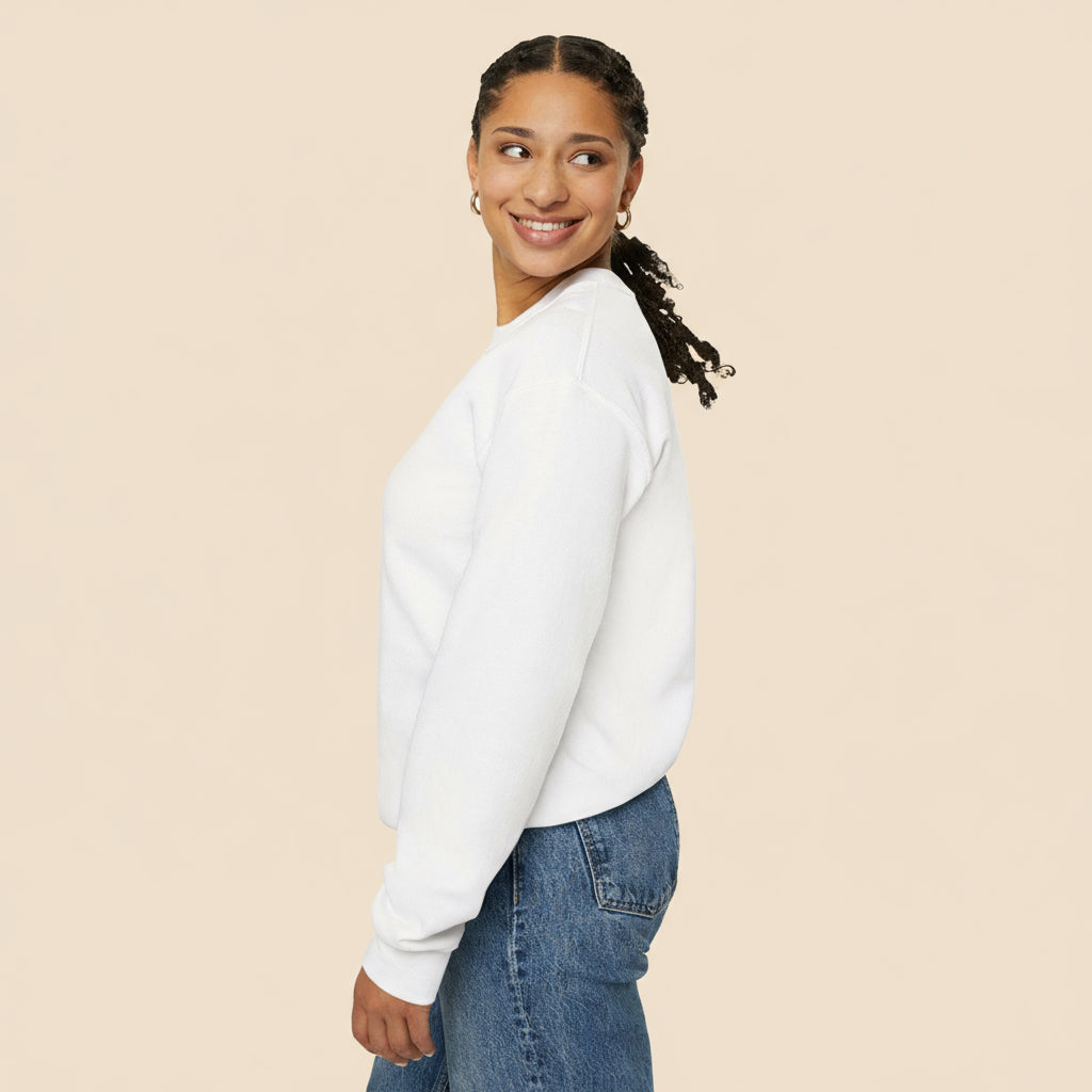 Woman wearing a white sweatshirt and blue jeans on a tan background