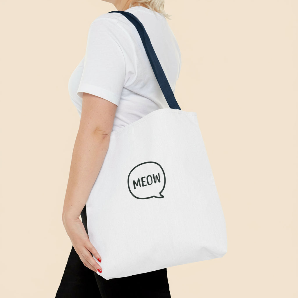 Person wearing a white tote bag with 'MEOW' print on a tan background