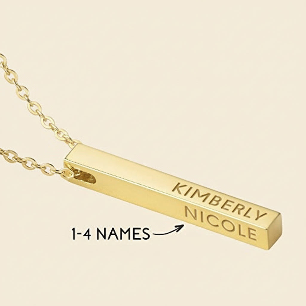 Gold necklace with a bar pendant engraved with 'KIMBERLY NICOLE' on a light background