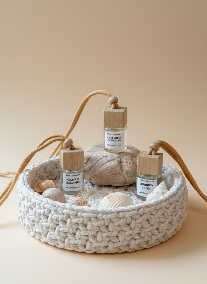 Three small glass bottles with wooden tops on a beige surface