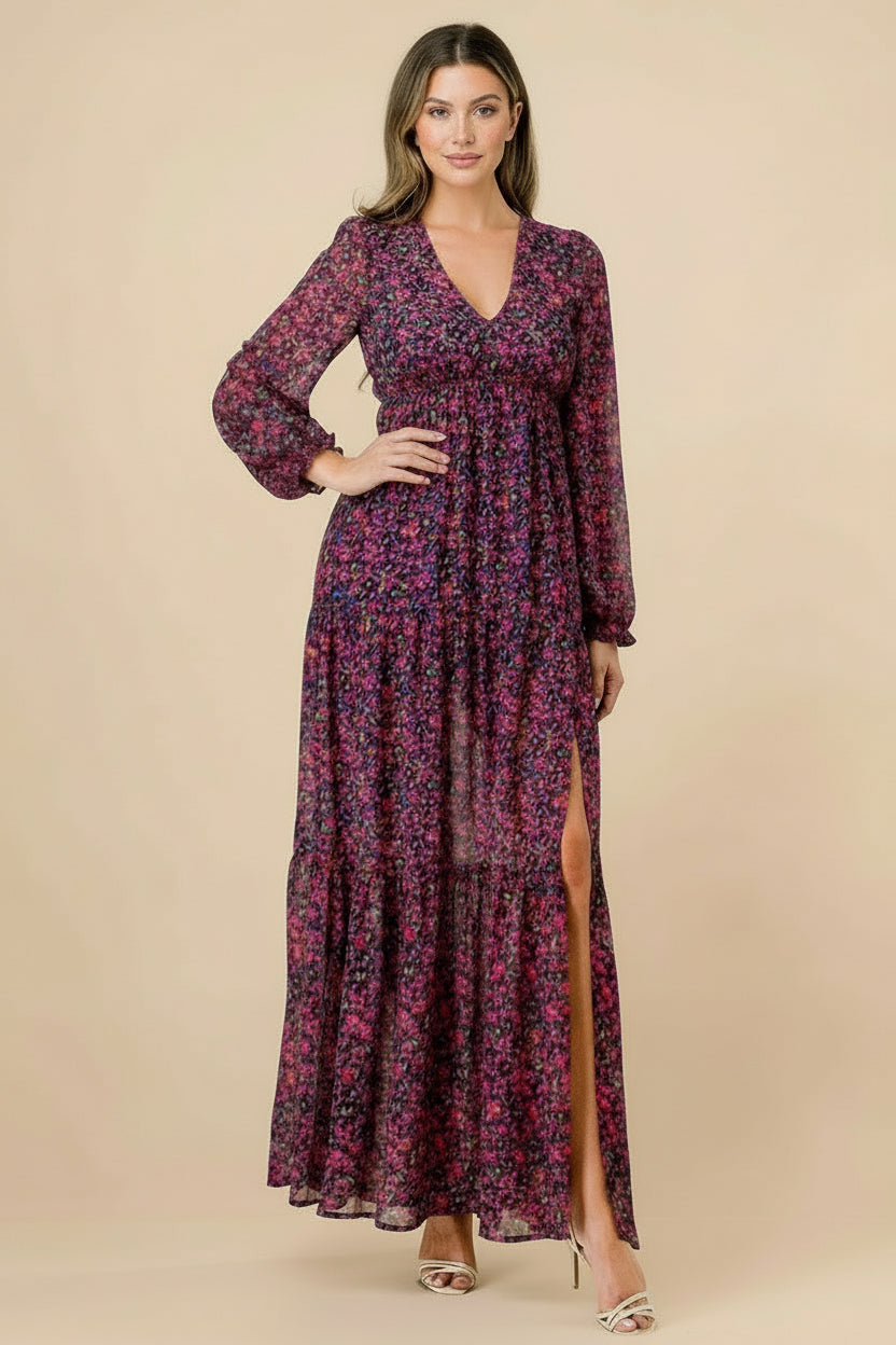 Woman wearing a long floral dress with a slit on a tan background