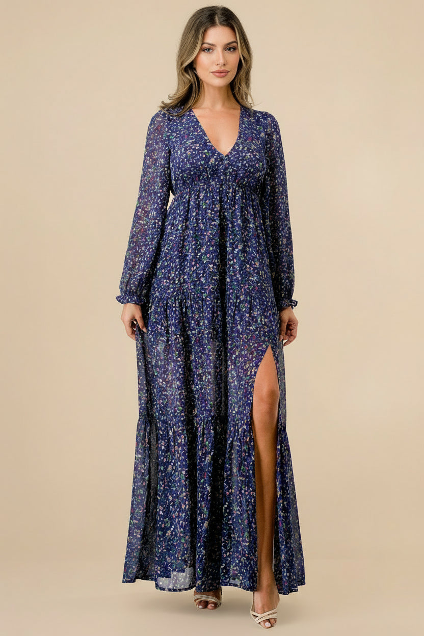 Woman wearing a long-sleeve, floral-patterned dress with a slit on a tan background