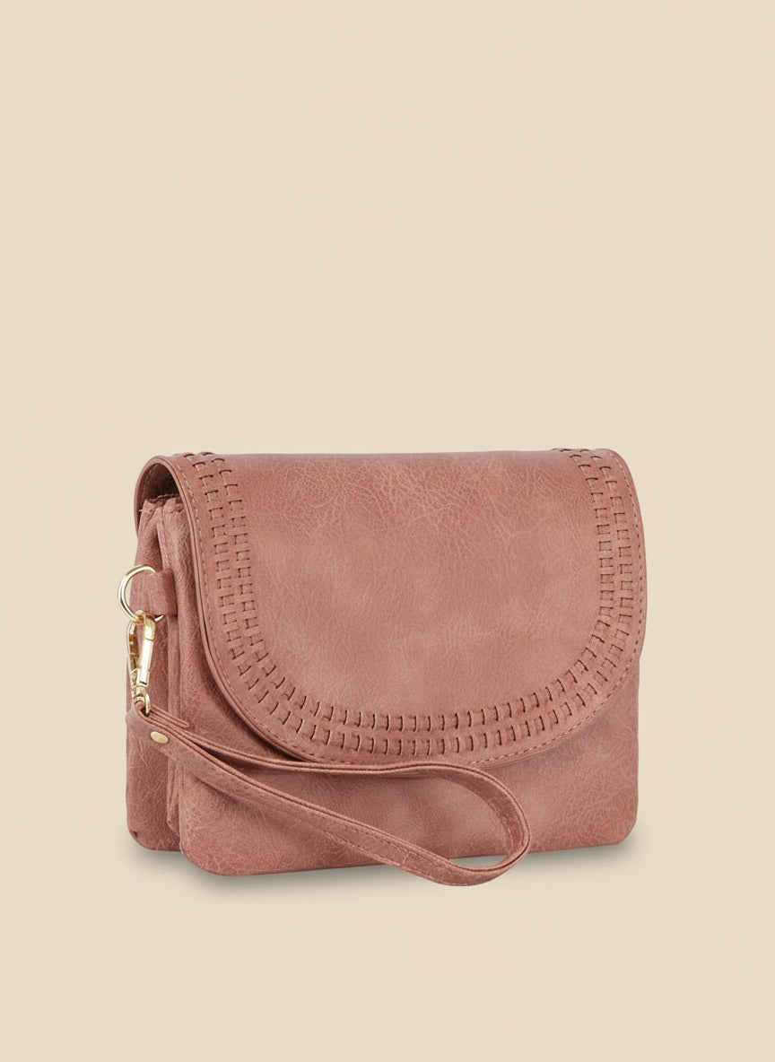 Pink suede handbag with a strap on a white background