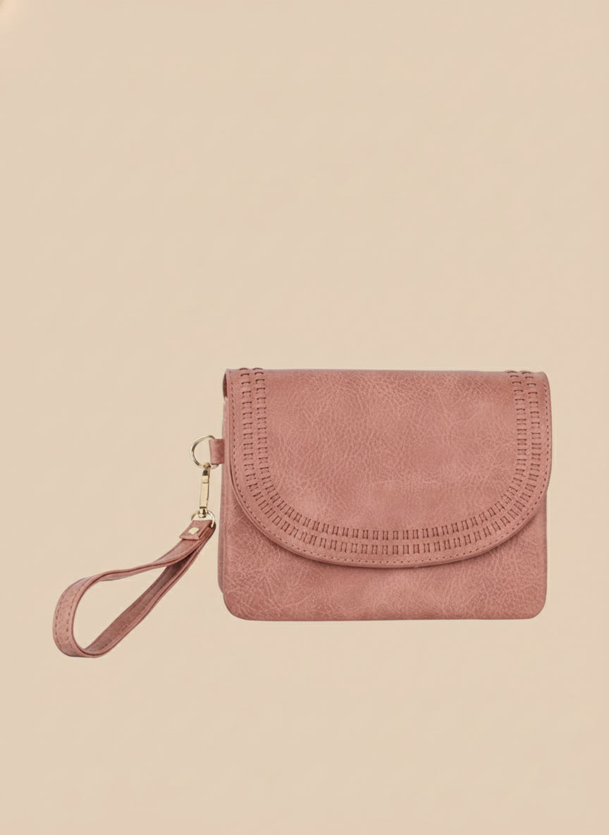 Pink suede clutch bag with a strap on a white background