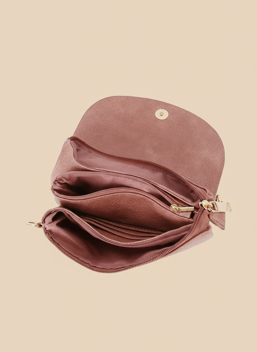 pikn leather clutch bag with gold zipper on a tan background