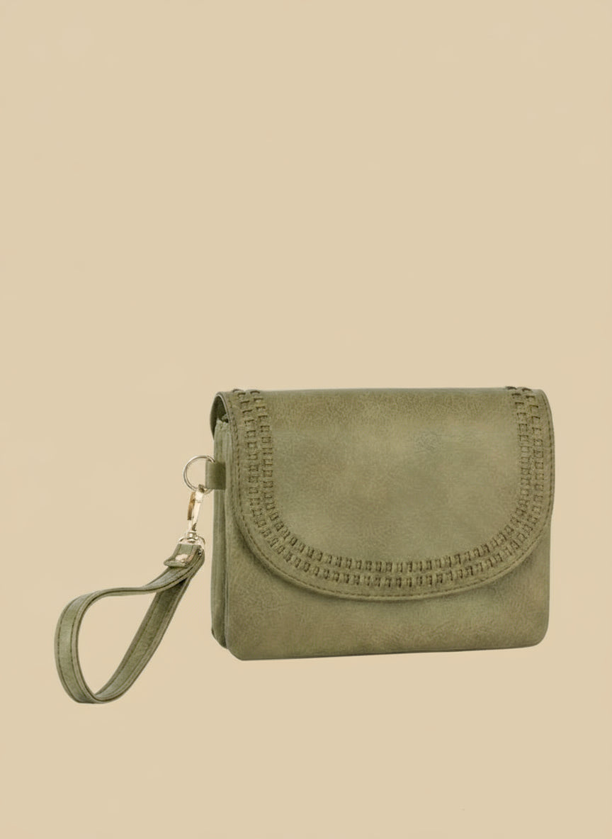 Green clutch bag with wrist strap on a tan background