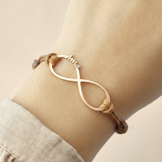 Infinite bracelet with names on a wrist against a light background