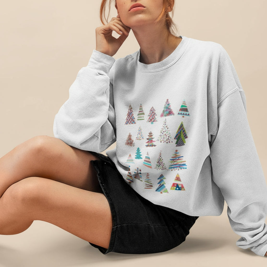 Person wearing a light gray sweatshirt with colorful tree pattern on a tan background