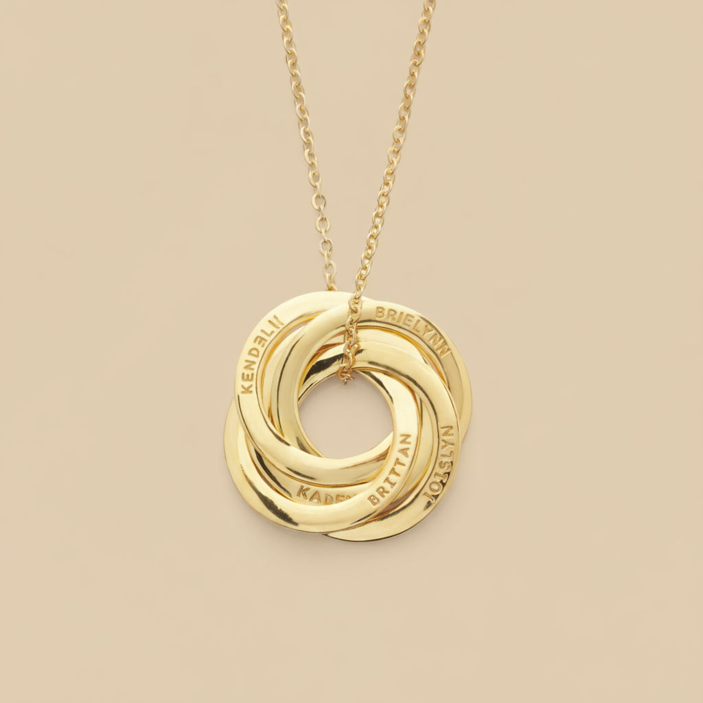 Gold necklace with interlocking rings on a light tan background