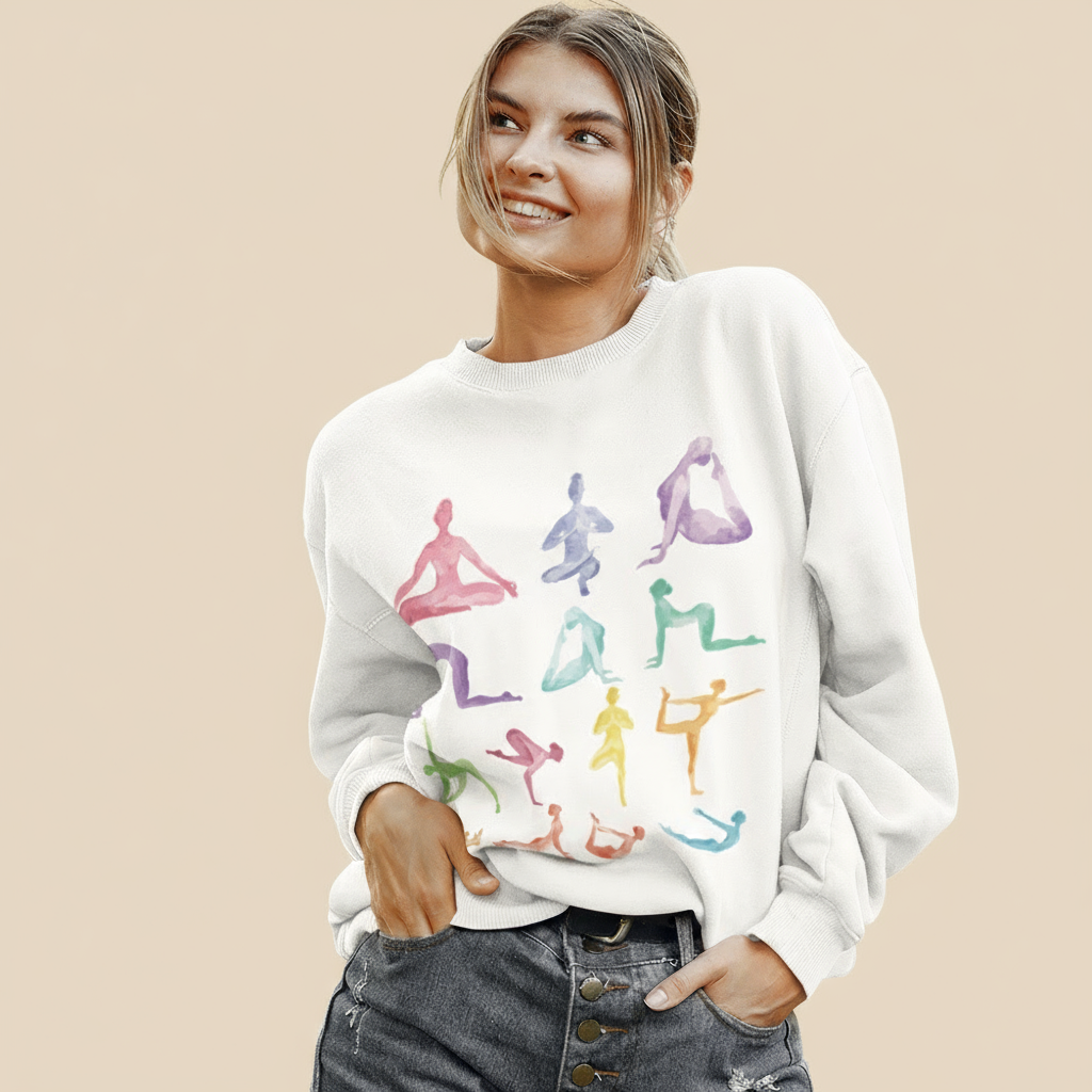 Woman wearing a white sweatshirt with colorful yoga pose illustrations.
