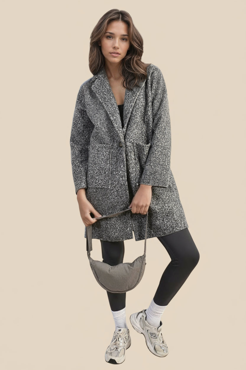 Woman wearing a textured gray coat with a beige background