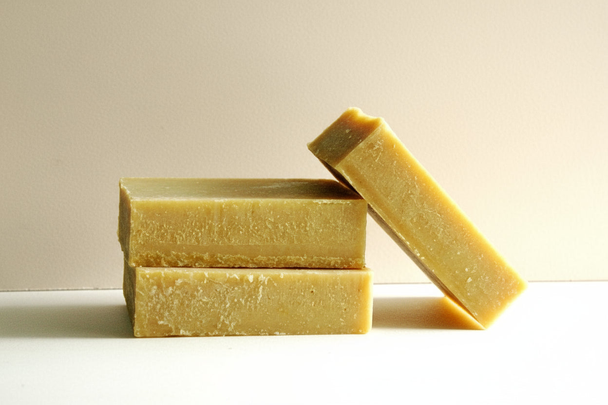 Three bars of yellow soap stacked on a white background