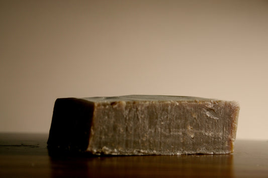 Bar of soap on a wooden surface with a plain background