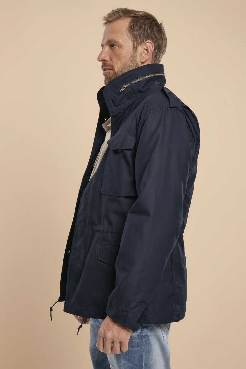 Man wearing a navy blue jacket on a light tan background