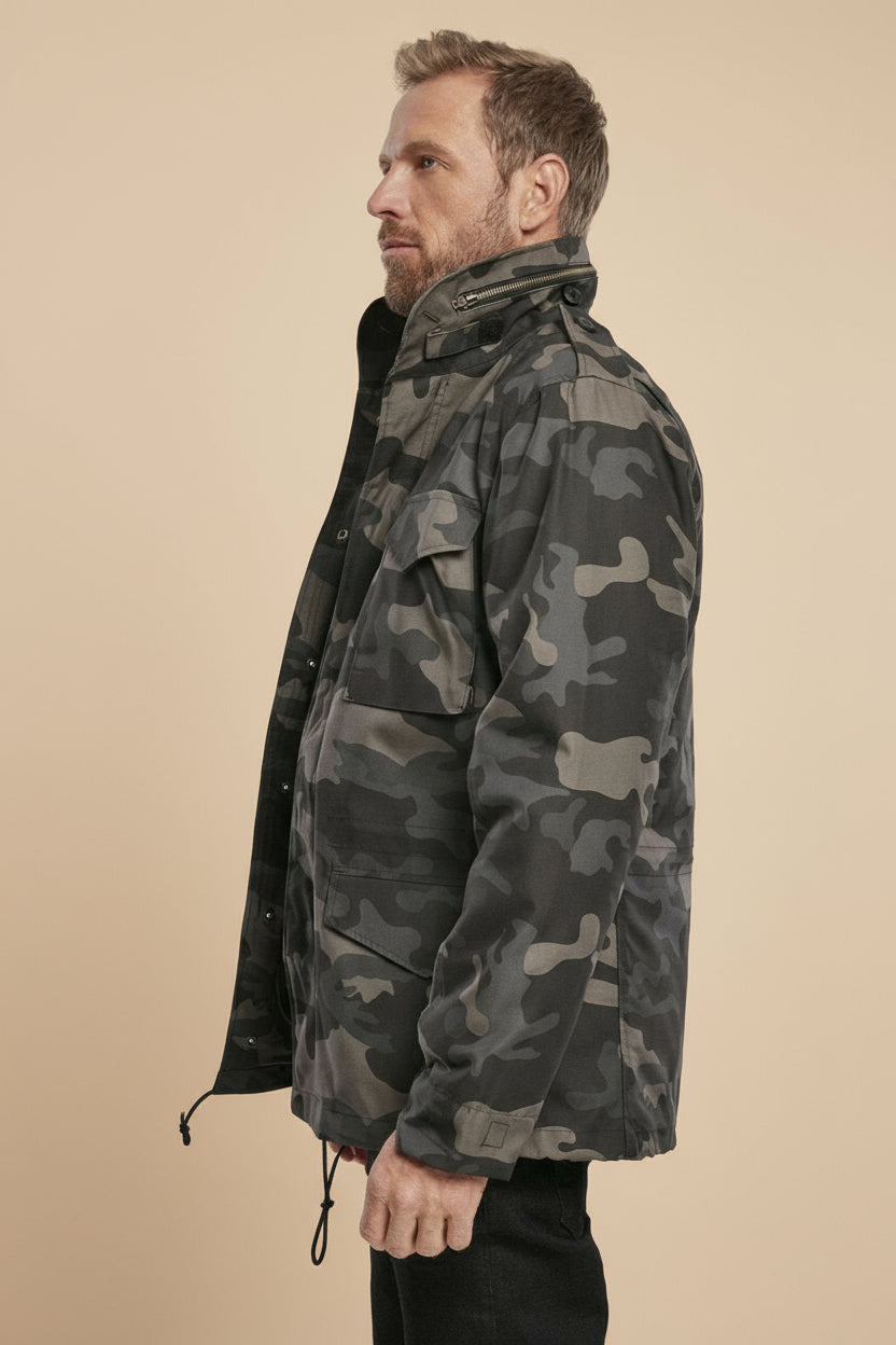 Man wearing a camouflage jacket on a tan background