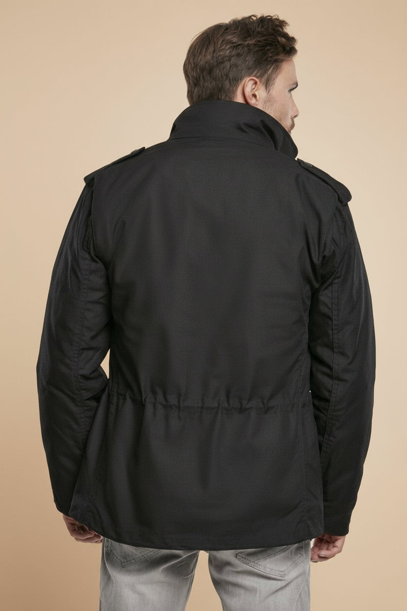 Man wearing a black jacket on a tan background