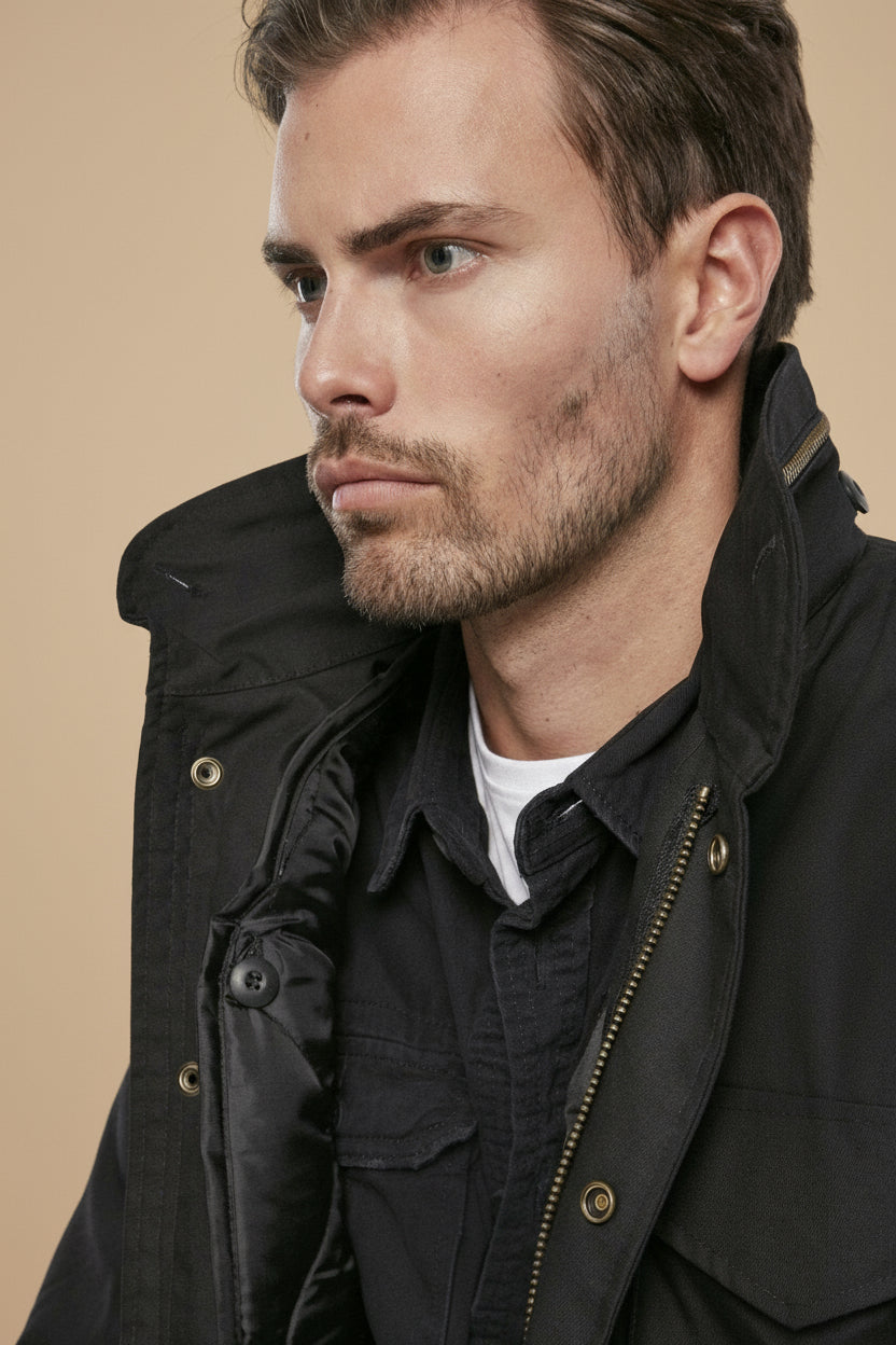 Man wearing a black jacket against a plain background