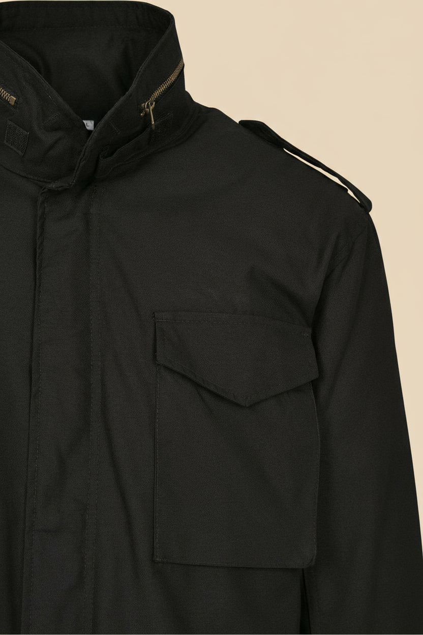 Black jacket with a pocket and zipper details on a tan background