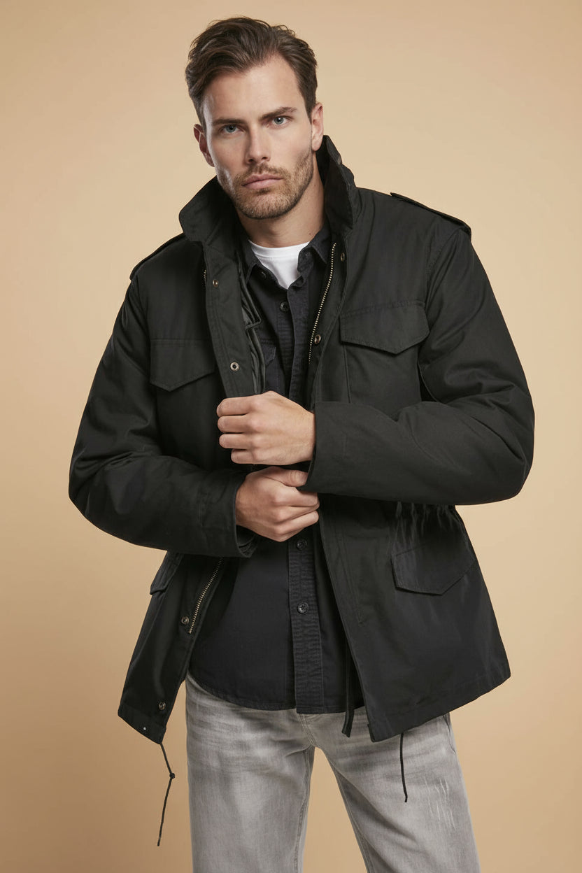 Man wearing a black jacket on a tan background